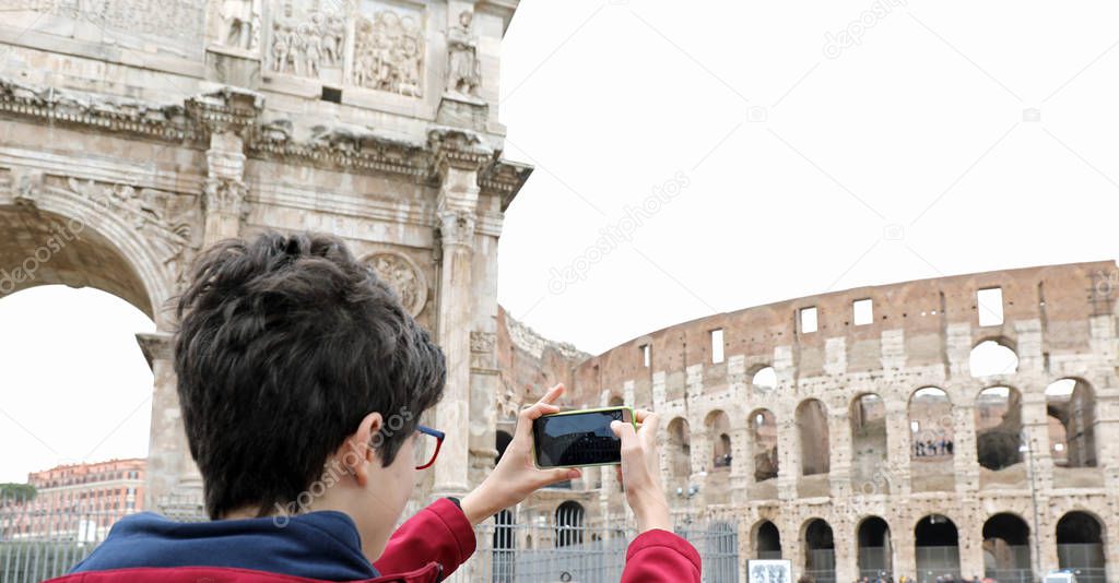 boy photographs the Colosseum in Rome