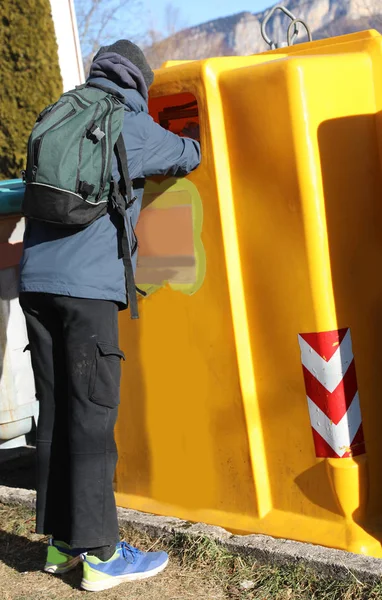 Pobre chico con una mochila buscando en el cubo de basura para someth —  Fotos de Stock