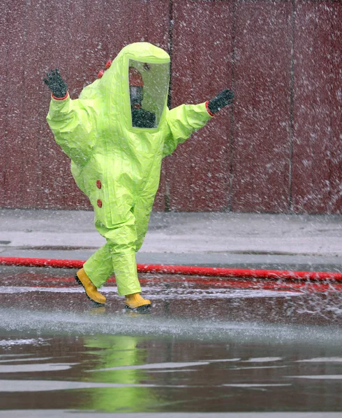 Bombero lleva un traje protector fosforescente para extinguir una f — Foto de Stock