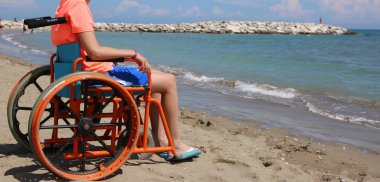 tekerlekli sandalyedeki çocuk denize hayran
