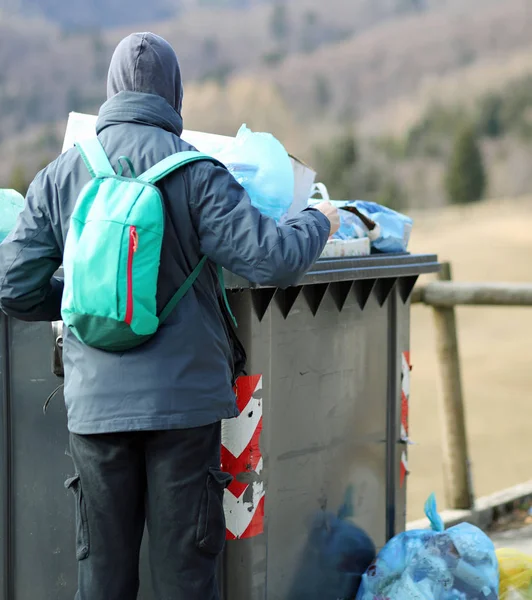 Arme jongen zoekt naar iets om te eten in het vuilnis bin — Stockfoto
