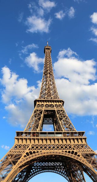 Eiffel Tower in Paris France with blue sky and clouds in background
