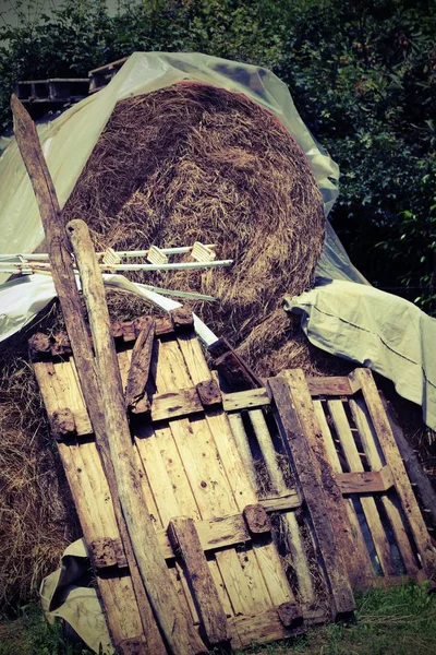Большой стог сена с деревянными поддонами на ферме — стоковое фото