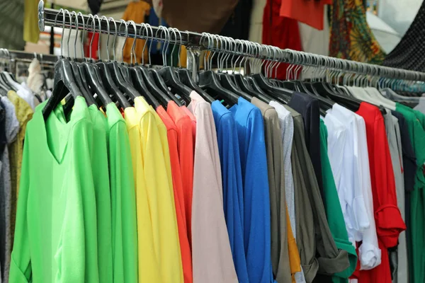 Ropa de pie en el mercado con muchas camisetas de algodón de colores —  Fotos de Stock