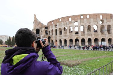 Kameralı genç fotoğrafçı Colosseum 'un fotoğraflarını çekiyor.