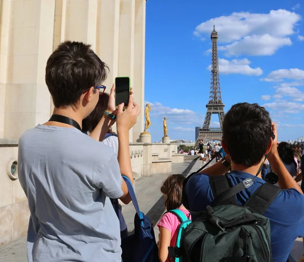 Young tourists take pictures of Eiffel Tower in Paris France fro — Stock Photo, Image