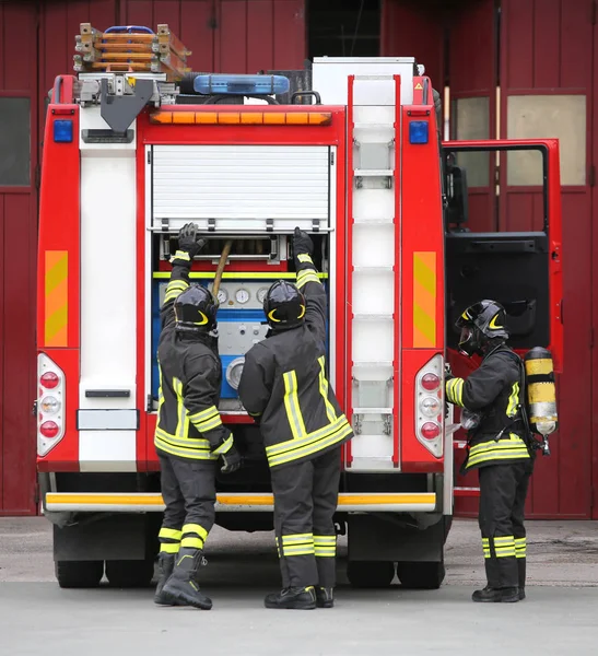 Три пожарных в действии — стоковое фото