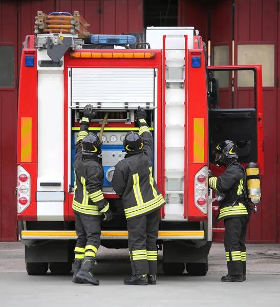 Three firemen in action — Stock Photo, Image