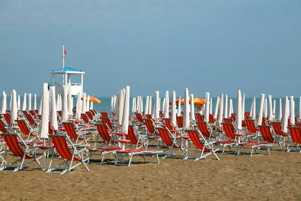 Tatil i kumlu plajda güneş şemsiye ve şezlong — Stok fotoğraf