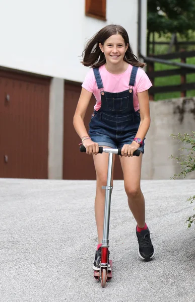 Glimlachend mooi klein meisje Downhill op haar scooter — Stockfoto