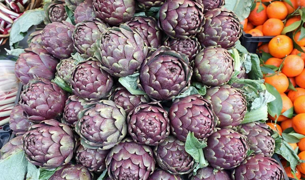 Alcachofras colhidas para venda e algumas clementinas — Fotografia de Stock