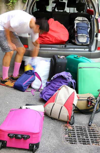 Pojken laddar bagaget till semestern i bilen — Stockfoto