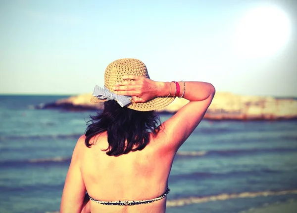 Νεαρή γυναίκα με ψάθινο καπέλο το καλοκαίρι — Φωτογραφία Αρχείου