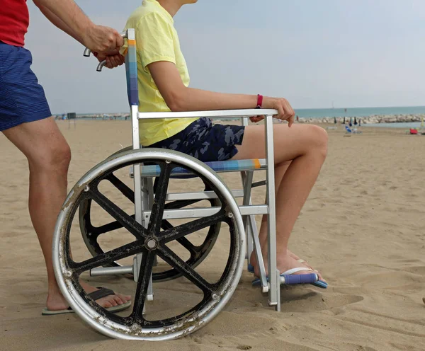 Vater schiebt seinen Sohn auf den Rollstuhl — Stockfoto