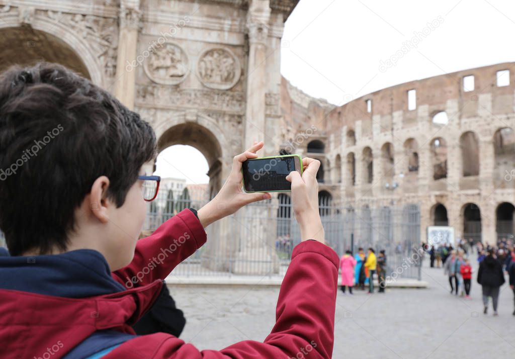 boy photographs the Colosseum with his cell phone