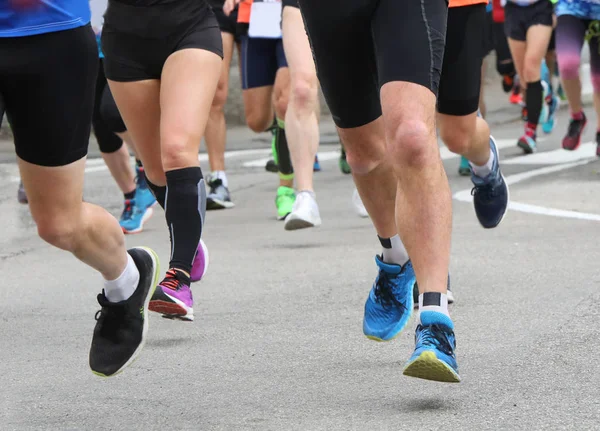 Pernas de corredores durante uma corrida na estrada — Fotografia de Stock