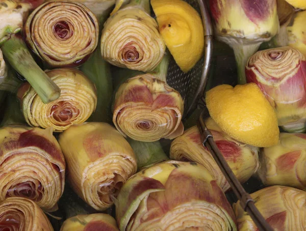 Raw artichokes on the water at market — Stock Photo, Image