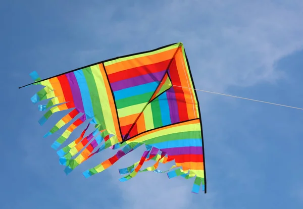 Drachen mit Regenbogenfarben am blauen Himmel — Stockfoto