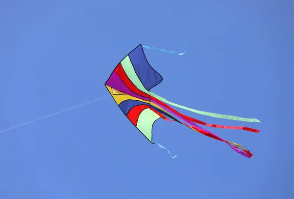 Colorful kite flies high in the sky — Stock Photo, Image