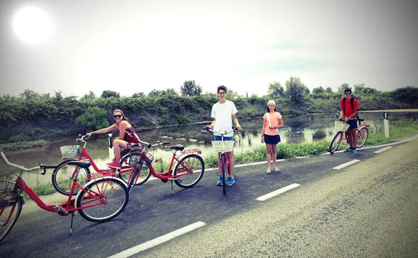 Family with young boys and little girl with bike on the road — Stock Photo, Image