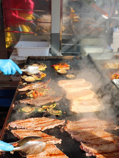 Cozinhar salsichas em uma barraca de comida de rua com legumes e toas — Fotografia de Stock