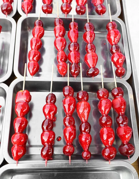 Pazar tezgahında satılık karamelize kırmızı meyve ile tepsiler — Stok fotoğraf