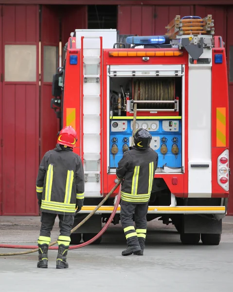 Пожежники і пожежна машина — стокове фото