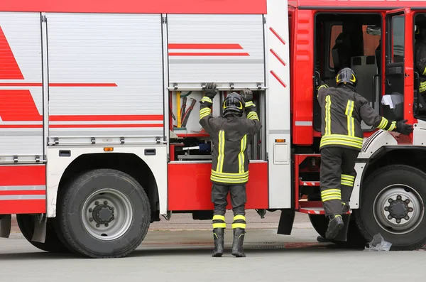 Los bomberos y el camión de bomberos —  Fotos de Stock