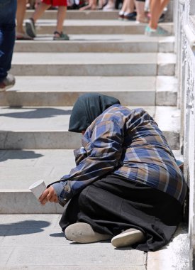 Venedik'te köprüde yıpranmış giysiler crouches ile yaşlı kadın ve