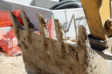 bir inşaatta kazı malzemesi işlemek için büyük kova 