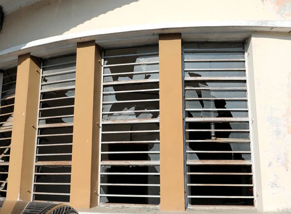 Вікна зі скляним покриттям повністю розбиті вандалами і металевим брусом — стокове фото