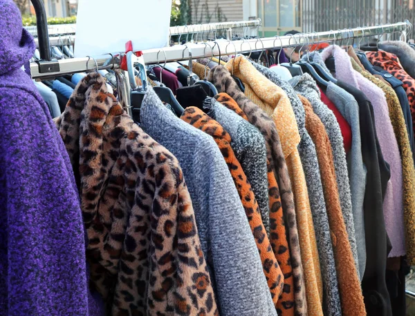 Vêtements et fourrures suspendus dans la stalle du marché en hiver — Photo