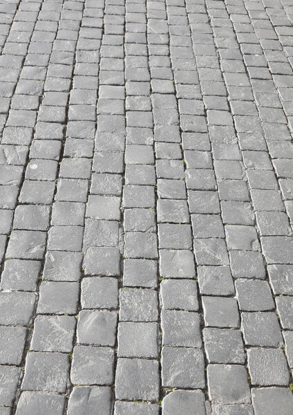 Background of gray tiles called in Italian Sampietrini or pave in France typical floor in Saint Peter Square in Vatican City