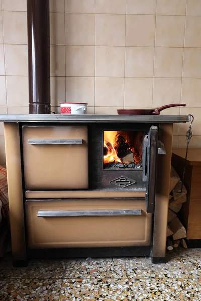 Vieja estufa con un fuego y las ollas con alimentos calientes —  Fotos de Stock