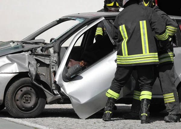 Brandweerlieden snijden de lakens van een beschadigde auto — Stockfoto