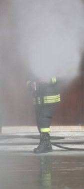 itfaiyeci bir yangın söndürmek için bir köpük kullanır