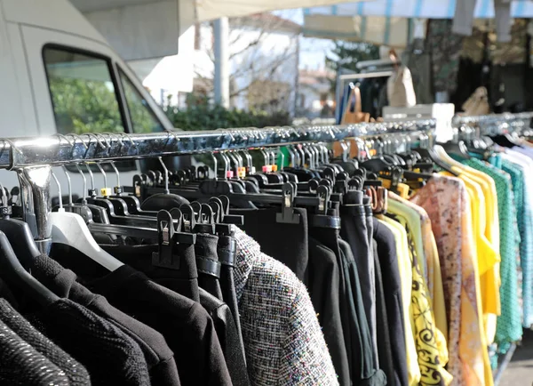 Mucha ropa colgando en el puesto del mercado — Foto de Stock