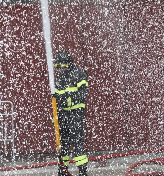 Μαχητής της φωτιάς χρησιμοποιεί αφρό όπως το χιόνι κατά τη διάρκεια της φωτιάς — Φωτογραφία Αρχείου