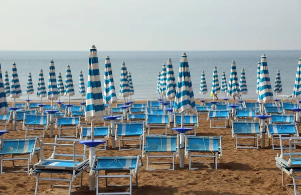 Umbrele de soare și șezlonguri pe plaja de nisip a stațiunii i — Fotografie, imagine de stoc