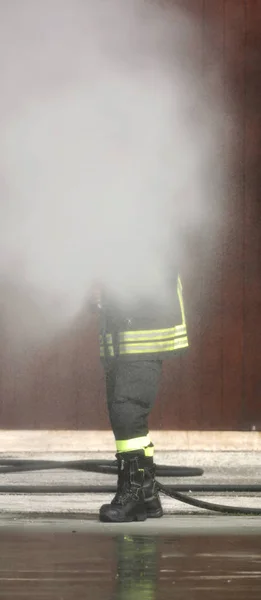 Strażak gasi ogień z hydrantem — Zdjęcie stockowe