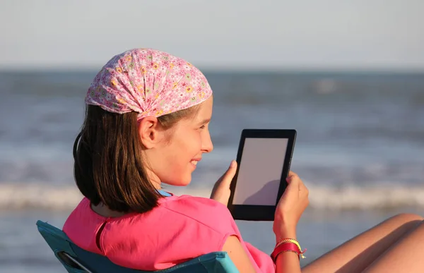 Pretty little girl reads her ebook — ストック写真