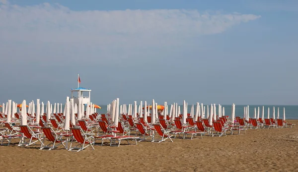 Kırmızı şezlonglar ve şemsiyeler plajda güneş.