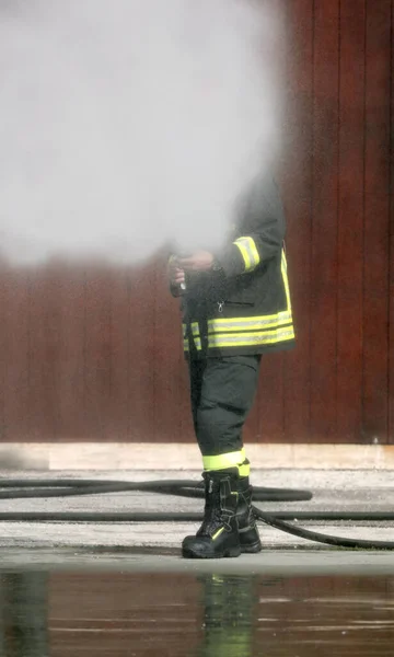 Tűzoltó a tűzoltó készülék habbal való oltása közben — Stock Fotó