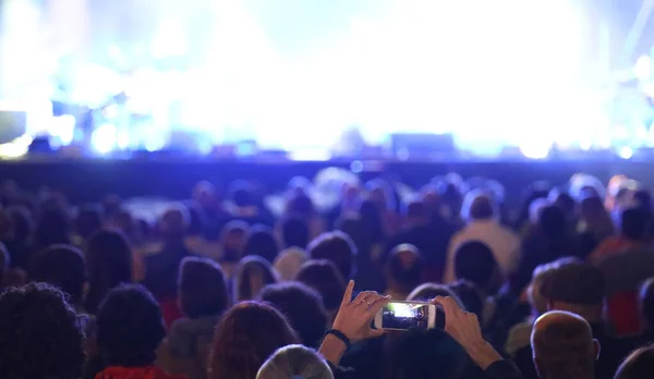 Chefs de personnes au concert et de nombreux projecteurs sur la scène — Photo