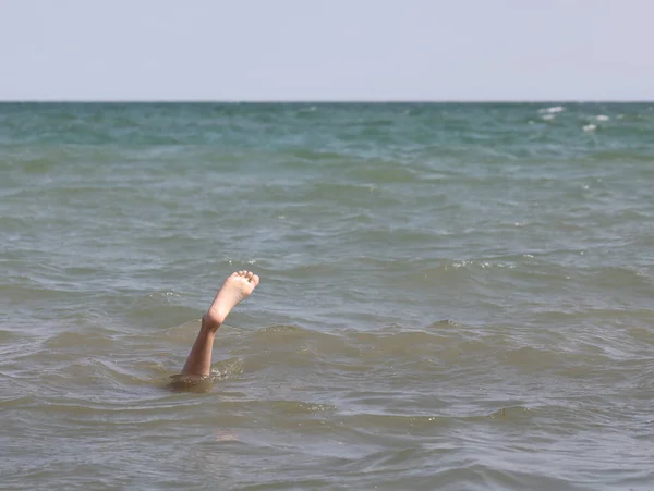 Pie solitario en medio del mar de la persona que está unde — Foto de Stock