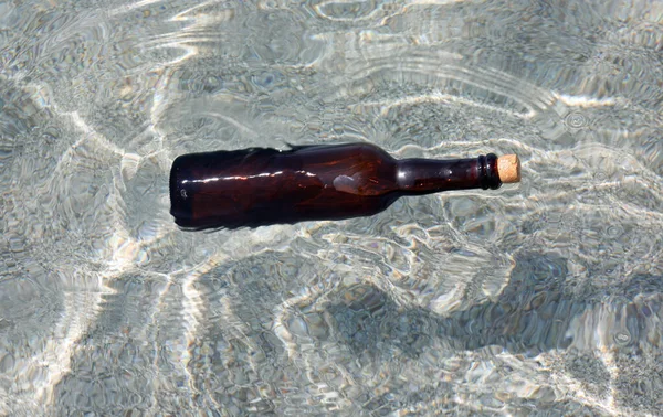 Бутылка стеклянной поплавки на воде — стоковое фото