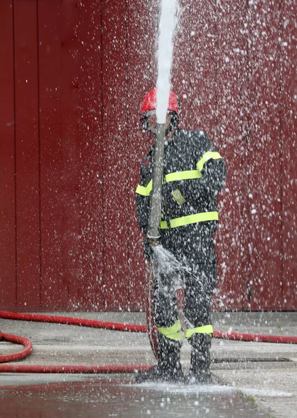 Pompier courageux avec bouche d'incendie — Photo