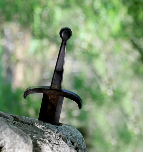 Espada en la piedra y fondo verde — Foto de Stock