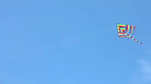 Высокий воздушный змей, летящий по голубому небу и копирующий пространство в текст — стоковое фото