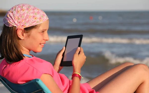 Petite fille lit l'ebook avec bandana — Photo